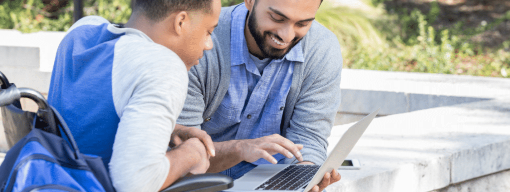 Two people of color looking at a laptop. 
