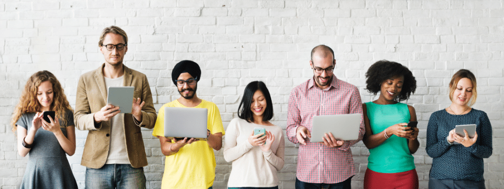 People standing in a line and looking at mobile devices in their hands.
