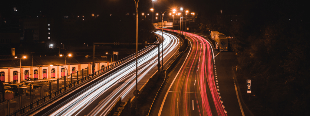 A motorway at night with light from cars speeding.