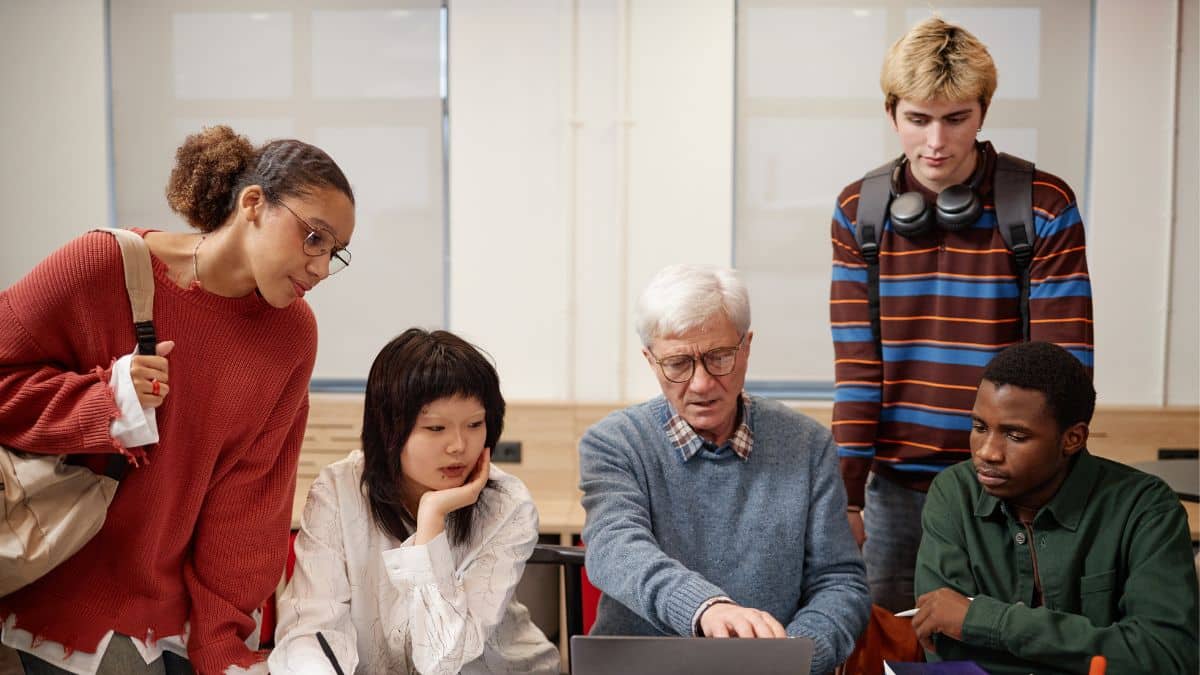 People sitting and starting at a table looking at a computer