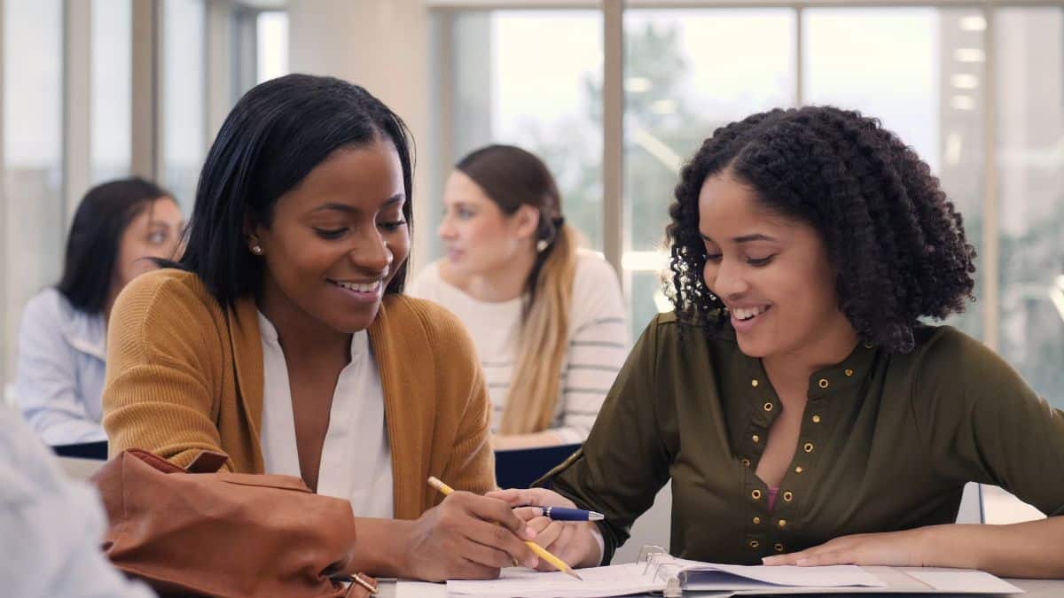 Two people looking an open notebook