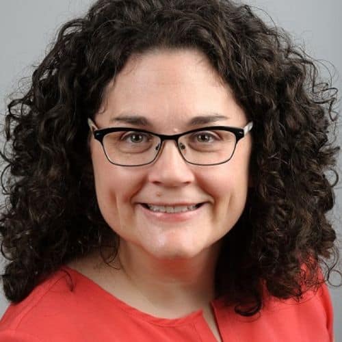Expert headshot, a white person with curly hair and glasses