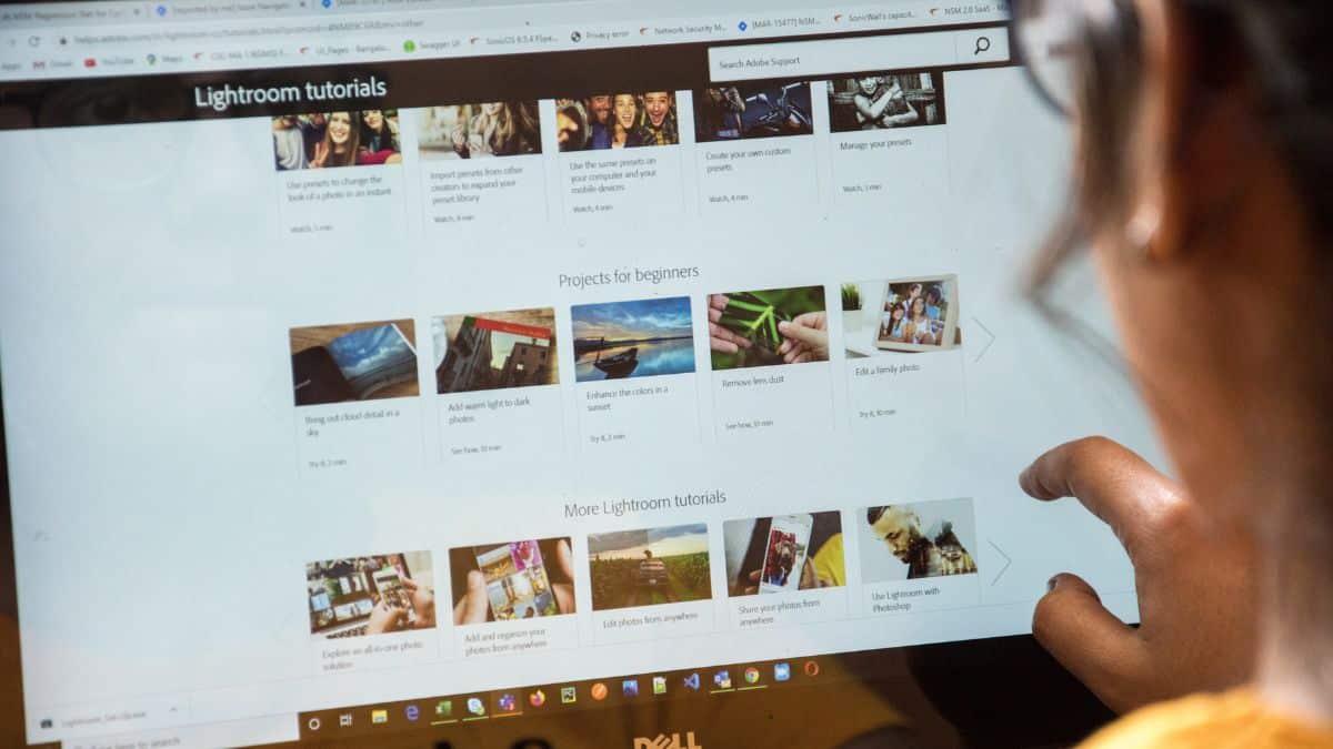 Feature image: a person looks over a laptop screen displaying a webpage with rows of thumbnail images.