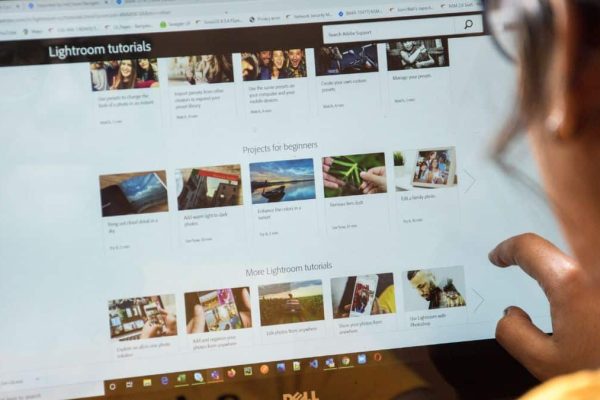 Feature image: a person looks over a laptop screen displaying a webpage with rows of thumbnail images.